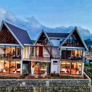 ein großes weißes Haus mit großen Fenstern in der Unterkunft Dream Cottage Nuwara Eliya in Nuwara Eliya