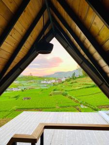 uma janela num telhado com vista para um campo verde em Dream Cottage Nuwara Eliya em Nuwara Eliya