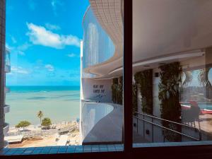 una finestra con vista sulla spiaggia di Edifício SKY Apto 1312 - ER Hospedagens a Maceió