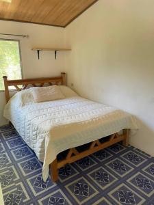 Bajo Boquete的住宿－Eucalyptus Cabin Boquete，卧室位于客房的角落,配有一张床