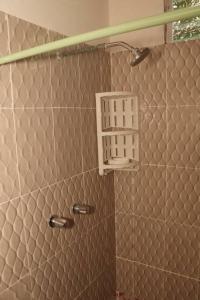 uma casa de banho com um chuveiro e uma parede de azulejos em Eucalyptus Cabin Boquete em Bajo Boquete