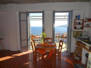 a dining room with a table and a view of the ocean at Ageranos in Vathi