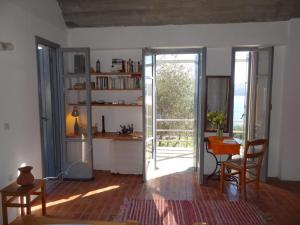 a living room with a door open to a kitchen with a table at Ageranos in Vathi