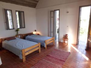 1 dormitorio con 2 camas en una habitación con ventanas en Ageranos, en Vathí