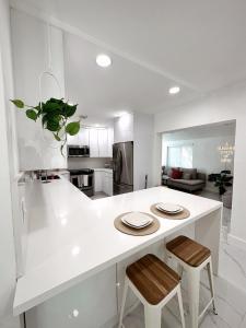 a kitchen with a white island with two stools at NEW Comfy and Modern House near Miami Airport in Miami