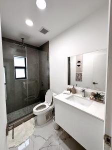 La salle de bains est pourvue de toilettes, d'un lavabo et d'une douche. dans l'établissement NEW Comfy and Modern House near Miami Airport, à Miami