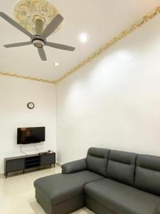 sala de estar con sofá y ventilador de techo en Chloe's Homestay, en Kuala Terengganu