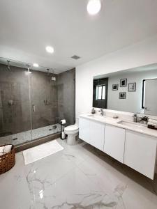 a bathroom with two sinks and a shower and a toilet at NEW Comfy and Modern House near Miami Airport in Miami