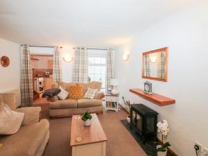 un soggiorno con un divano e un tavolo di Primrose Cottage a Paignton Altre 26 foto