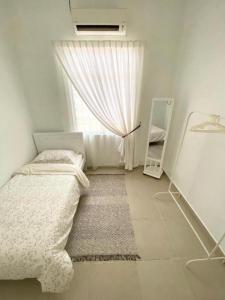 ein kleines Schlafzimmer mit einem Bett und einem Fenster in der Unterkunft Chloe's Homestay in Kuala Terengganu