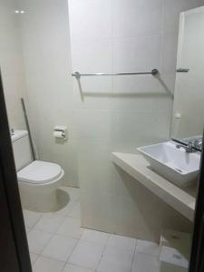 La salle de bains blanche est pourvue de toilettes et d'un lavabo. dans l'établissement Anjung vista guest house Husm kubang kerian, à Kubang Kerian