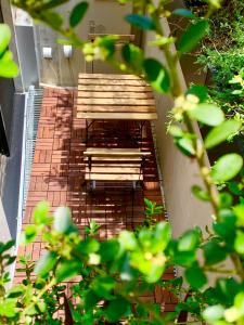 2 bancos de madera sentados en un patio de ladrillo en Ken's Place四谷 en Tokio
