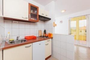 a white kitchen with a sink and a window at Apartment in Slatine with sea view, balcony, air conditioning, Wi-Fi (4784-2) in Slatine