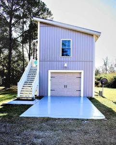 a garage with a large door on the side of it at Secluded Tiny House by the Marsh with Hunting Island Beach Pass in St. Helena Island