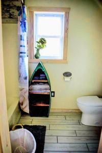 a bathroom with a toilet and a window at Secluded Tiny House by the Marsh with Hunting Island Beach Pass in St. Helena Island