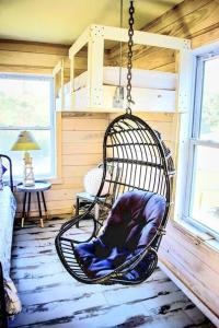 una habitación con una silla colgante en una habitación en Secluded Tiny House by the Marsh with Hunting Island Beach Pass, en St. Helena Island
