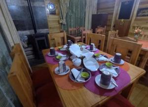 una mesa de madera con platos y platos. en Chiloe Seta, en Ancud