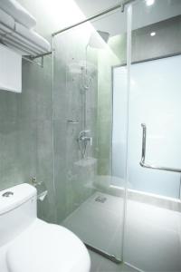 a bathroom with a glass shower and a toilet at Fives Hotel DNP in Johor Bahru