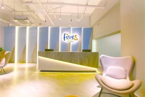 a lobby with two chairs and a fos sign at Fives Hotel DNP in Johor Bahru