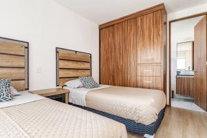 1 dormitorio con 2 camas y paredes de madera en Depto excelente ubicación en Narvarte, en Ciudad de México
