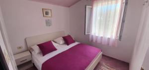 a bedroom with a bed with purple sheets and a window at Apartment in Sevid with Seaview, Terrace, WIFI (4746-1) in Sevid