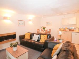 un soggiorno con un divano e un tavolo di Bluebell Cottage a Paignton