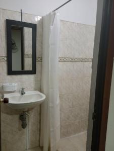 W łazience znajduje się umywalka, lustro i prysznic. w obiekcie Hotel Bethesda w mieście Aguachica