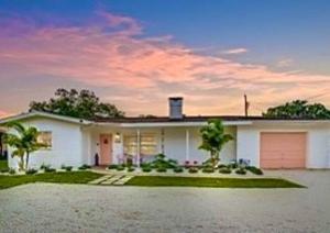 una gran casa blanca con entrada en The Pink Flamingo Mid Century Heated Pool Paradise, en Sarasota