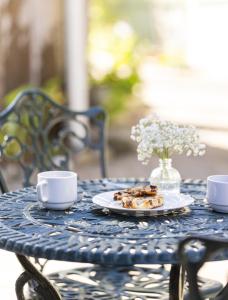 a blue table with two cups and a plate of food at Centrella Hotel, a Kirkwood Collection Hotel in Pacific Grove