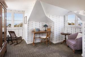 a room with a table and chairs and windows at Centrella Hotel, a Kirkwood Collection Hotel in Pacific Grove