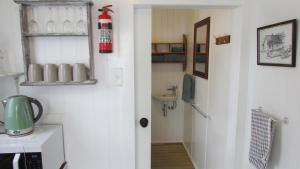 a room with a kitchen with a sink and a door at Self-contained Studio- 5 min to Waihi township, 10 min drive to Waihi beach in Waihi