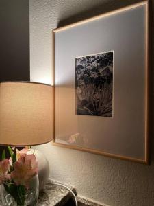 a picture on a wall with a lamp and flowers on a table at Shores of Panama Unit 1209 in Panama City Beach