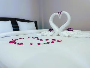 two white swans forming a heart on a bed at Terminal 58 Airport in Ban Mut Dok Khao