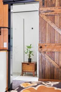 a sliding barn door in a room with a potted plant at The Beach Shack at Dalmeny in Dalmeny