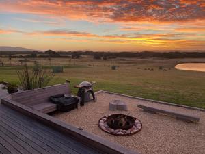 a backyard with a fire pit and a bench at Majuba Country Lodge in Kalgan