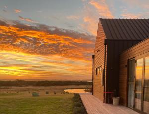 a building with a sunset in the background at Majuba Country Lodge in Kalgan