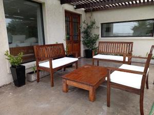 3 bancos de madera y una mesa en un patio en EL PINAR2 en Balneario El Cóndor