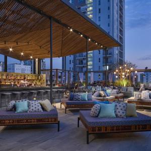 eine Dachterrasse mit Sofas und einer Bar in der Unterkunft Baitong Hotel & Resort Phnom Penh in Phnom Penh