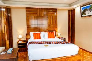 a hotel room with a large bed with wood paneling at Tara Phendeyling Hotel in Thimphu