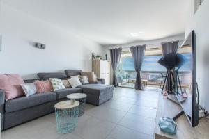 Una sala de estar con un sofá y vista al mar. en LB Vacation Rentals I Admire Panoramic Ocean Views Through Walls of Windows, en Cannes
