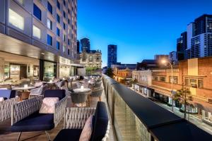 um bar no último piso com cadeiras e mesas num edifício em InterContinental Perth City Centre, an IHG Hotel em Perth