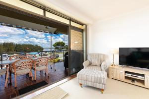 a living room with a balcony with a table and chairs at Braemar 3 in Forster
