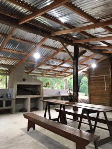 un pabellón con 2 mesas de picnic y una cocina en Cabaña Los Nietitos en Tranqueras