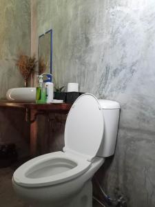 a bathroom with a white toilet and a sink at Surf and Skate Duli El Nido By Kiteclub Palawan in El Nido