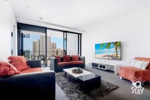 a living room with two couches and a tv at KIDS STAY FREE in OCEAN View 1 Bedroom SPA Apartment at Circle on Cavill - Q STAY in Gold Coast