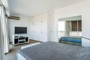 1 dormitorio con 1 cama y TV de pantalla plana en Apartment near to Recoleta & Puerto Madero en Buenos Aires