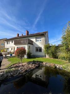 a house with a pond in front of it at Modern 3Room Apartment Free Wifi Netflix and free Parking in Hamm