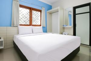 a large white bed in a room with a window at TwoSpaces Living at Panorama Villas in Batu