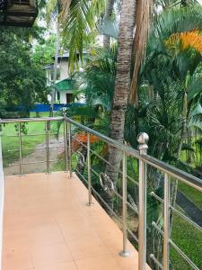 balkon z ogrodzeniem i palmą w obiekcie Green Parrot Family Resort w mieście Polonnaruwa