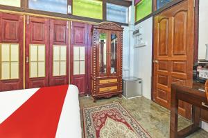 - une chambre avec un lit, un bureau et des armoires en bois dans l'établissement OYO Home 90332 Jentayu Homestay Pontian, à Pontian Kecil